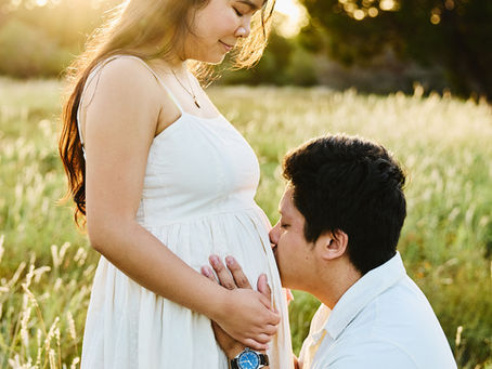 Father kissing the baby bump during a maternity photography session in South Austin