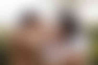 Sweet and emotional family moment at Zilker Botanical Garden in Austin, showing parents kissing their children in soft golden light.