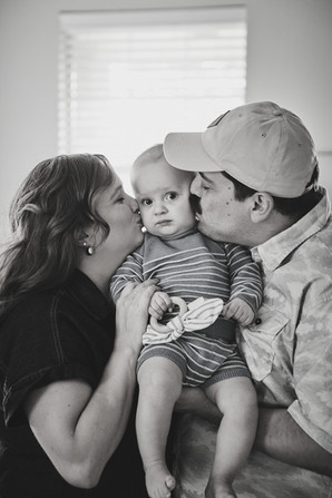 Parents kissing their baby boy on the cheek