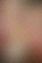 Close-up portrait of an expecting couple smiling softly during their home maternity session in Austin.