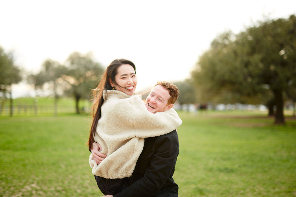 Playful couple laughing and hugging during an outdoor couples photo session in Austin