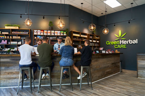 Retail staff assisting customers at a CBD shop counter, people-focused branding photography showing real customer interaction