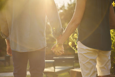Holding hands in warm morning light at Sunken Garden Georgetown TX, celebrating 45 years of love and togetherness.