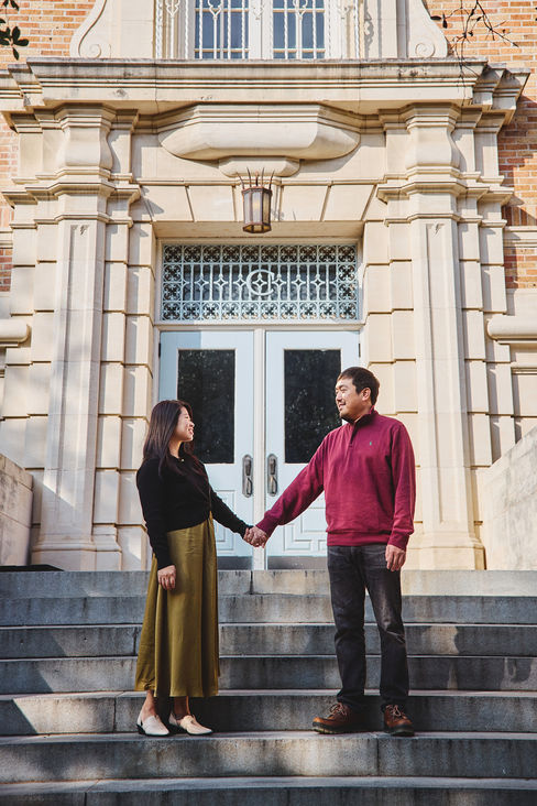 Couple holding hands on the steps of a historic UT Austin building during their family session.