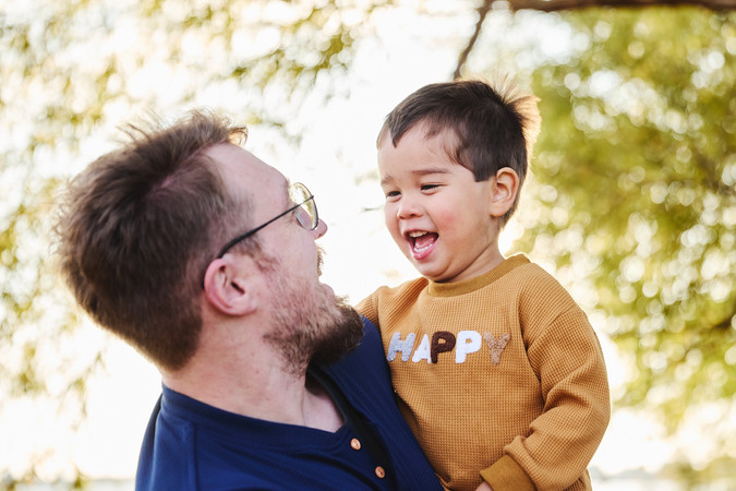 Father holding children at Lake Pflugerville Park, natural family photography north of Austin