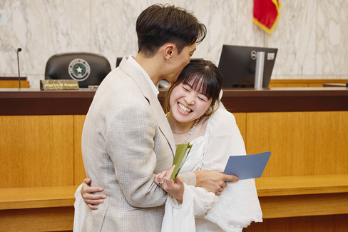 Newly married couple smiling together inside the Travis County Courthouse courtroom in downtown Austin