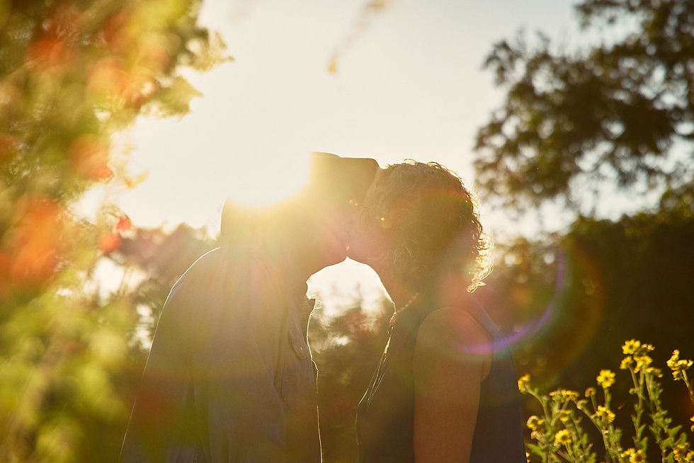 Couple sharing a gentle kiss under the morning sun at Sunken Garden in Georgetown TX during their 45th wedding anniversary photoshoot.
