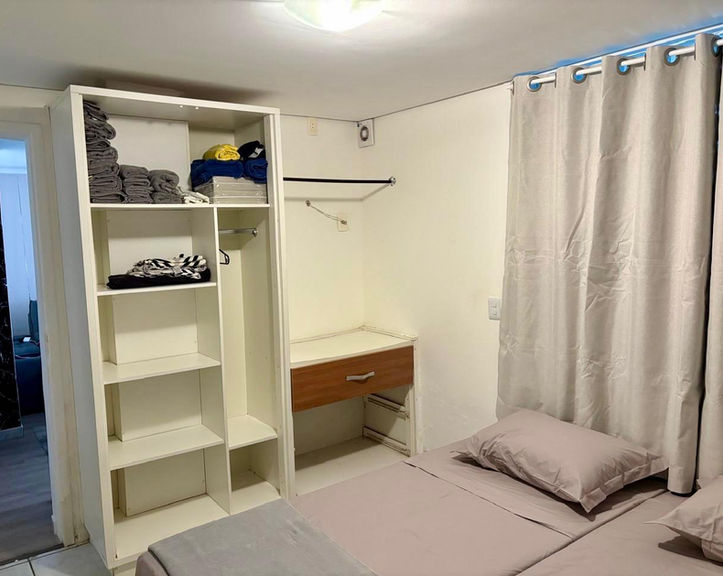 Quarto do Apartamento 54 com armário branco e escrivaninha.