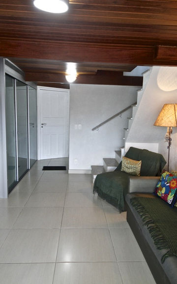 Sala de estar do Apartamento 29 com sofá e teto de madeira.