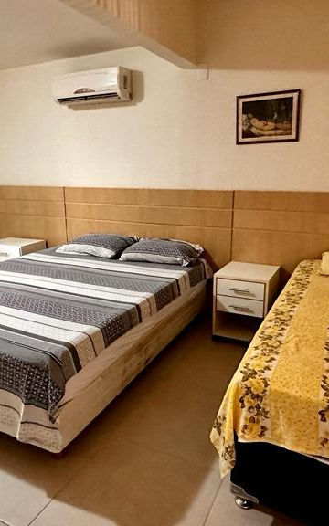 Quarto do Apartamento 23 com cama de casal e solteiro.