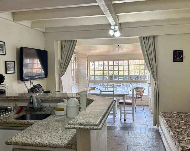 Cozinha integrada à sala no Apartamento 34 com balcão de granito