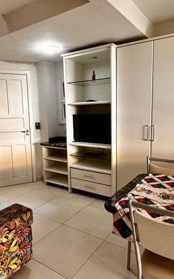 Sala integrada com mesa de jantar e sofá do Apartamento 23
