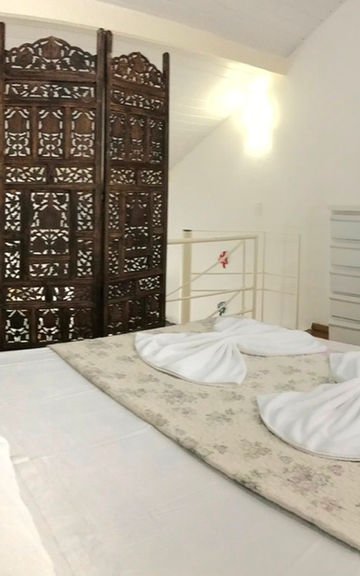 Quarto do Apartamento 50 com biombo de madeira entalhada.