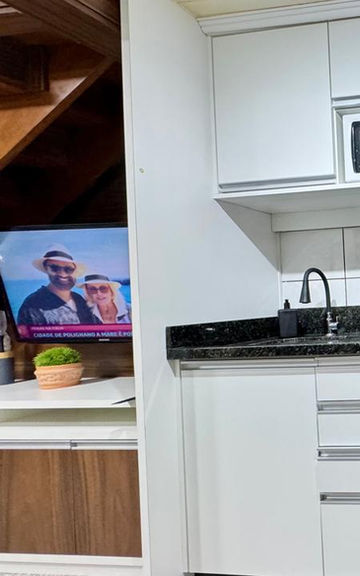 Cozinha planejada do Apartamento 32 com armários brancos e fogão.