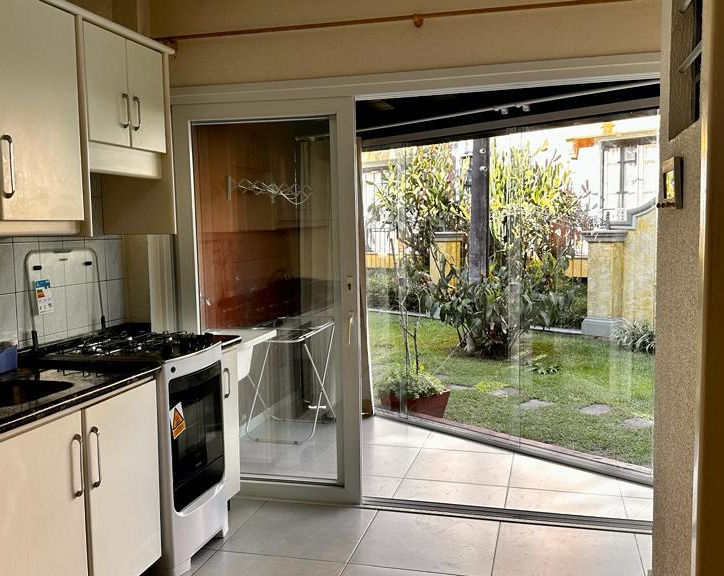 Cozinha do Apartamento 23 com vista para jardim gramado.