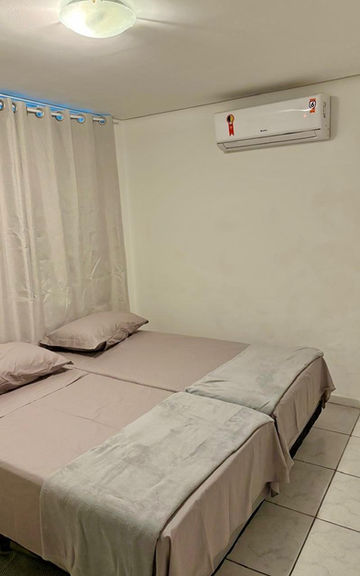 Quarto do Apartamento 54 com duas camas e ar-condicionado.