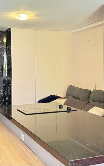 Cozinha integrada à sala no Apartamento 54 com bancada escura.
