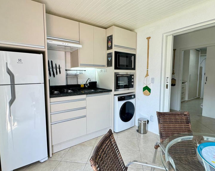 Cozinha planejada do Apartamento 07 com eletrodomésticos.