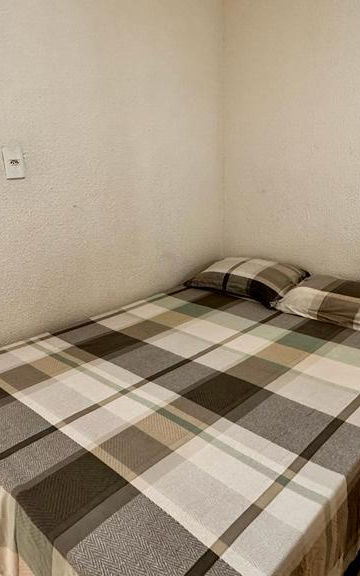 Cama de casal com enxoval xadrez no Apartamento 23