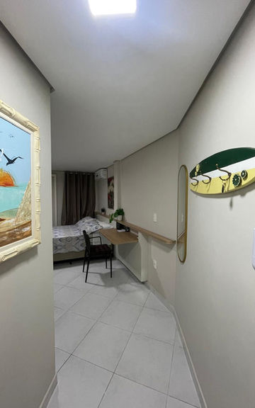 Corredor do Apartamento 53 com decoração praiana e escrivaninha
