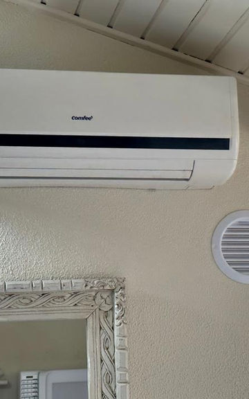 Aparelho de ar-condicionado split branco instalado na parede.