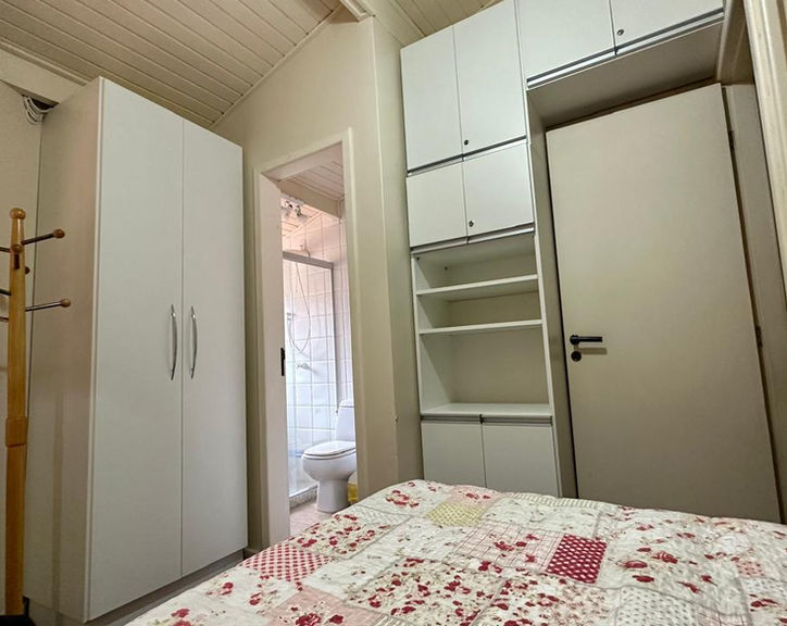 Quarto com armários brancos e cama no Apartamento 34