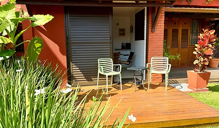 Varanda de apartamento térreo com deck de madeira e cadeiras