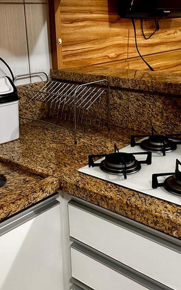 Cozinha do Apartamento 06 com cooktop branco e pia de granito.