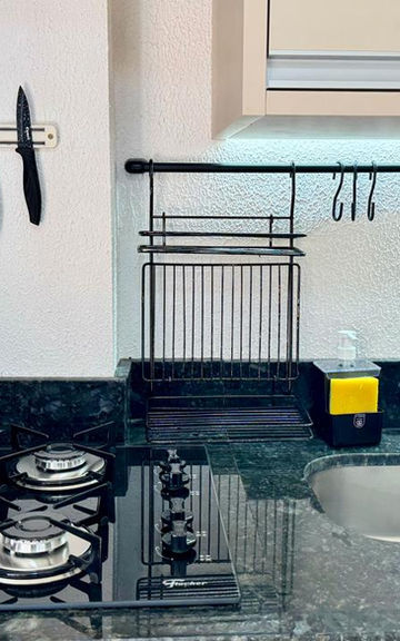 Cozinha com cooktop, pia e suporte magnético para facas.