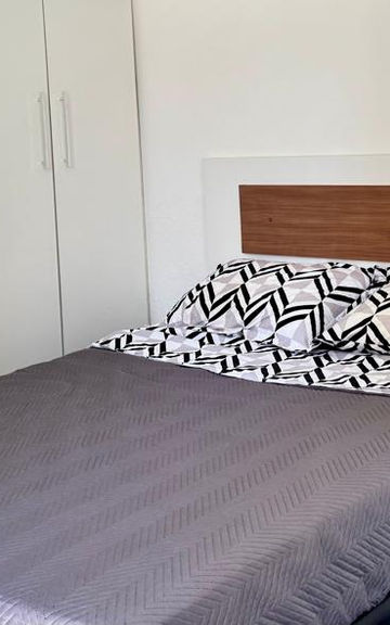 Quarto do Apartamento 54 com cama de casal e guarda-roupa.
