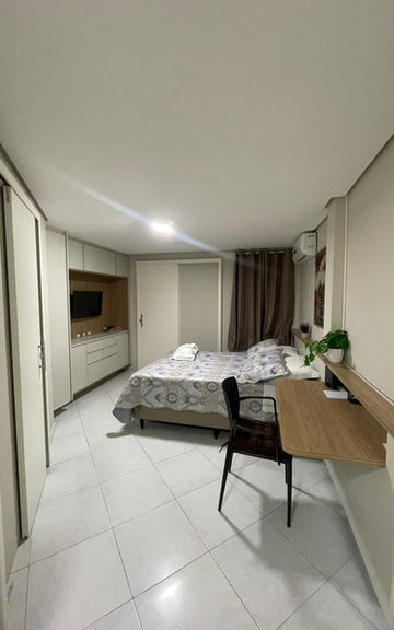 Quarto de casal moderno com bancada de trabalho no Apartamento 53