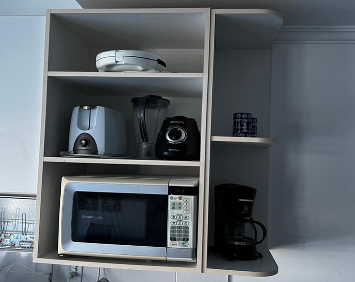 Armário de cozinha com micro-ondas, cafeteira e torradas