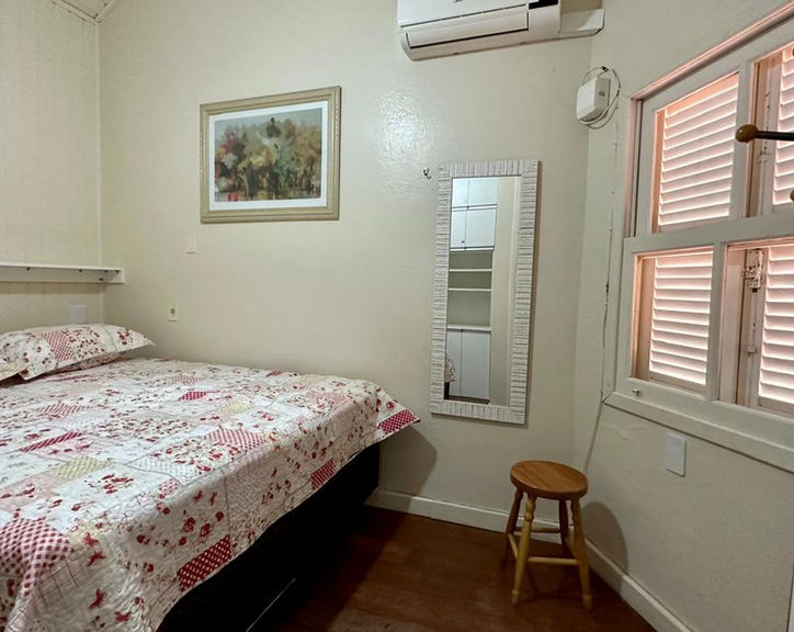 Quarto do Apartamento 34 com cama de casal e janela com veneziana