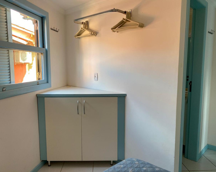 Armário planejado branco com detalhes em azul no Apartamento 33