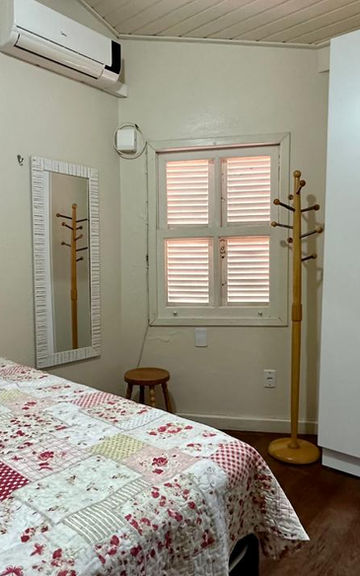 Quarto do Apartamento 34 com cama de casal e guarda-roupa branco.