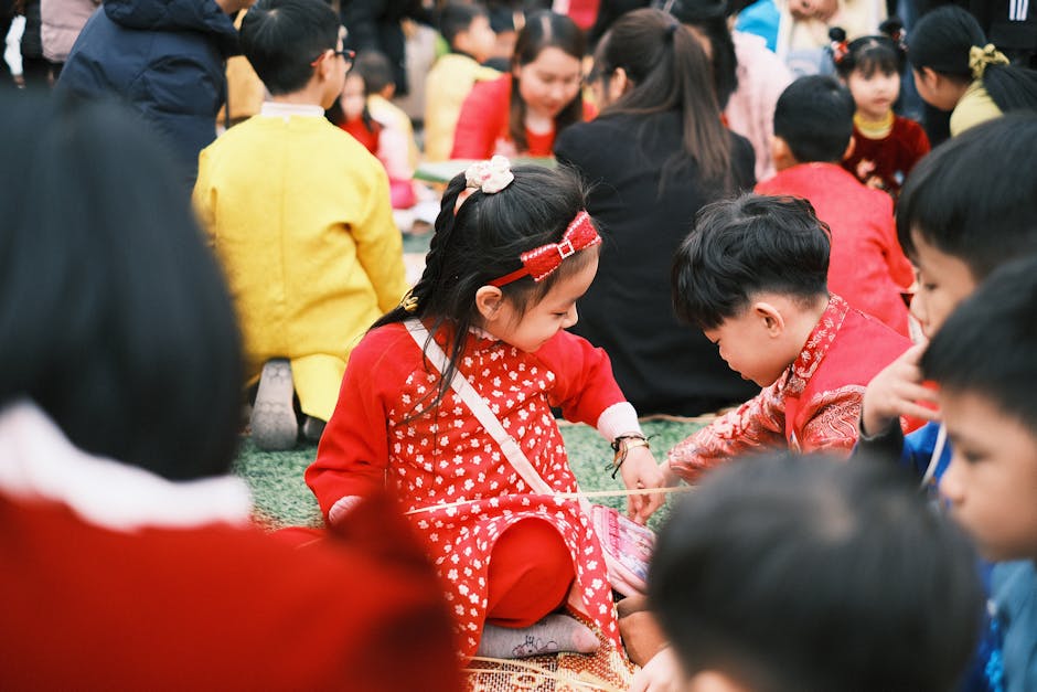 A group of children sitting on the grass in red