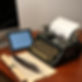 A computer, a tablet with keyboard, an old typewriter with paper, a piece of parchment, an