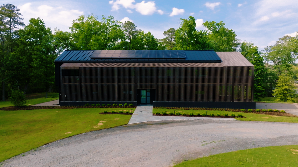 High-angle aerial view of the Nevills Creek House highlighting its energy-efficient design, including a black standing seam m
