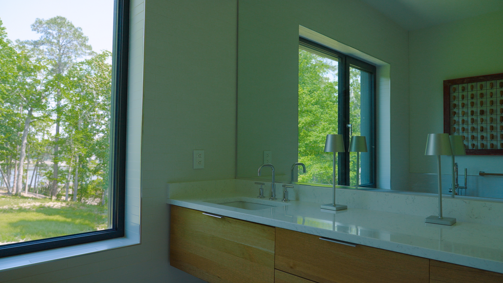 Modern bathroom at the Nevills Creek House featuring a floating wood vanity with a white countertop and dual faucets