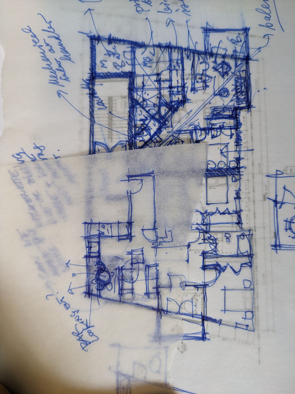 Overlapping ink sketches on translucent paper showing multiple revisions of a building layout. Labels, arrows, and room outlines are visible.