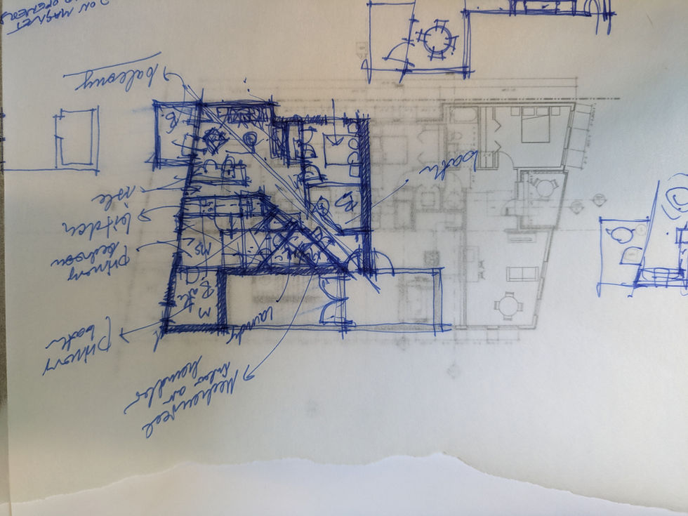 Blue ink hand sketch layered over a printed floor plan, showing rough outlines of walls, rooms, and annotations such as “hallway,” “bathroom,” and “kitchen.”