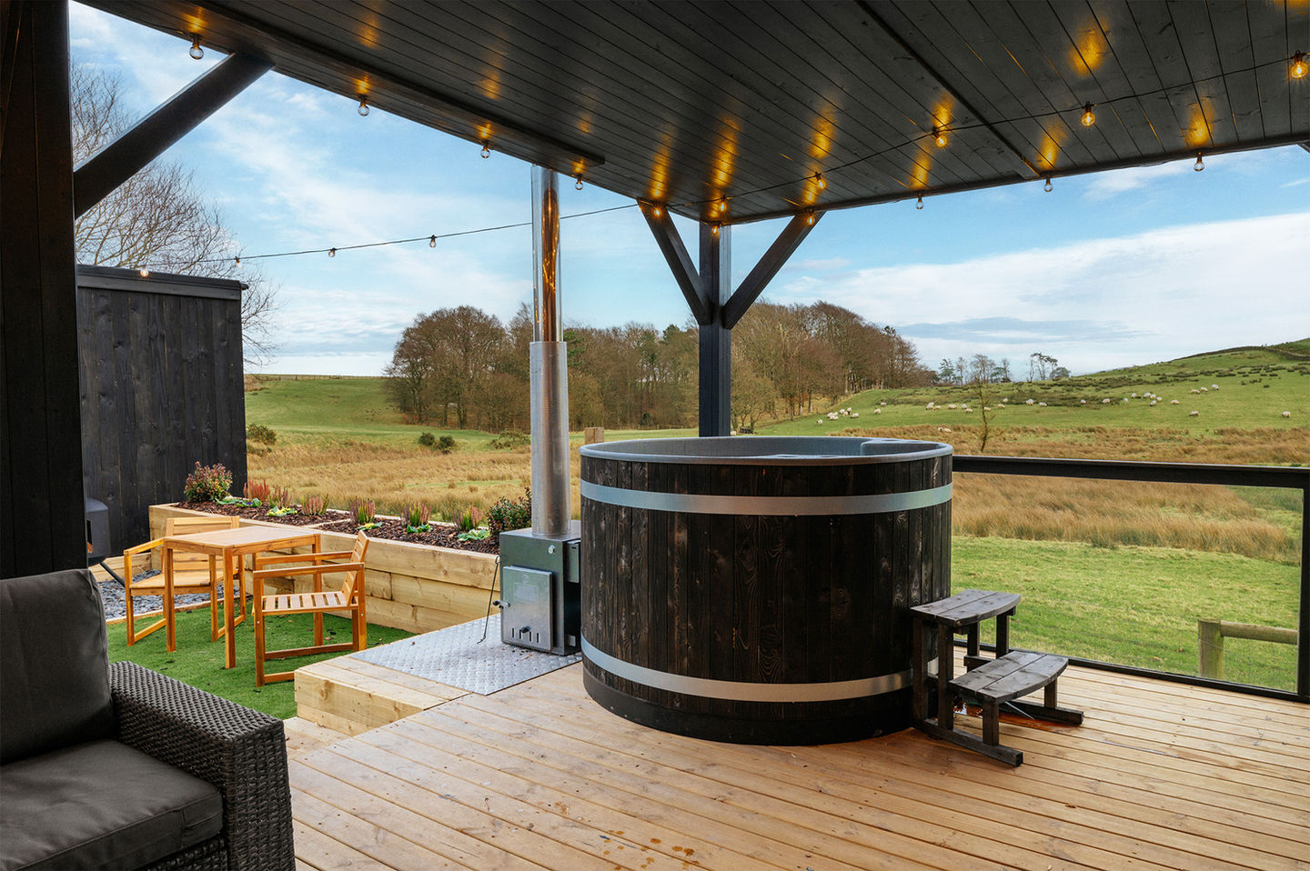 Relaxing hot tub surrounded by stunning countryside at Cloud Nine Retreat glamping pod.