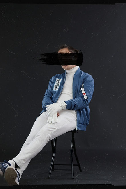 Vintage editorial film photo of a street racer sitting while wearing a blue windbreaker with japanese.