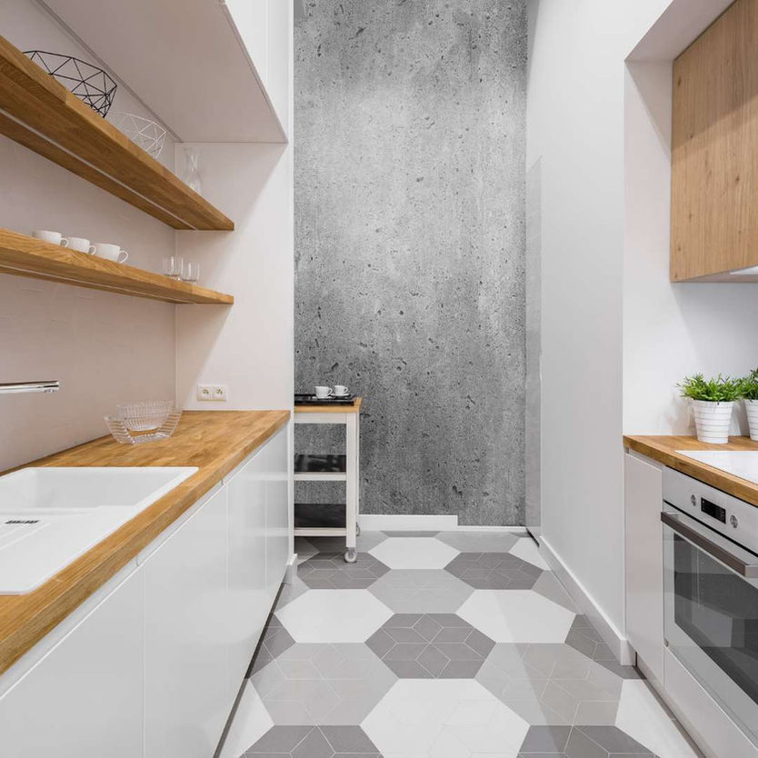 Minimalistic modern white kitchen with grey tones, hexagonal tiles and light wood countertop