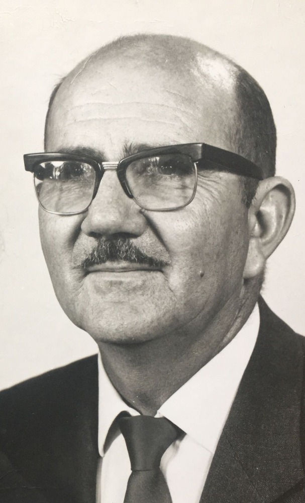 Black and white photo of a man wearing glasses in a suit
