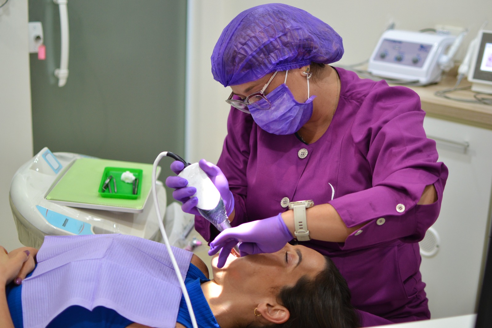 Dentista sorrindo e interagindo com paciente durante atendimento humanizado