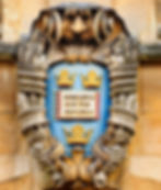an insignia with three crowns and a book