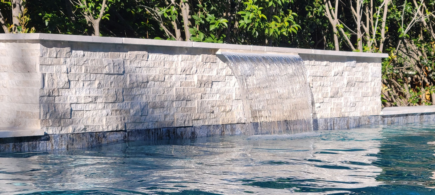ribbon style water fall into swimming pool.jpeg