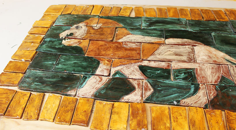 Many handmade tiles with a lion design glaxed on them
