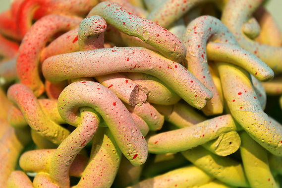 uplose image of a multi colored ceramic piece made of small rolled out log of clay